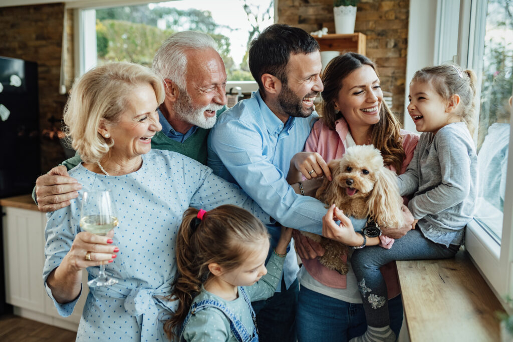 Famille multi-génération joyeuse avec un chien s’amuser tout en passant du temps ensemble à la maison.