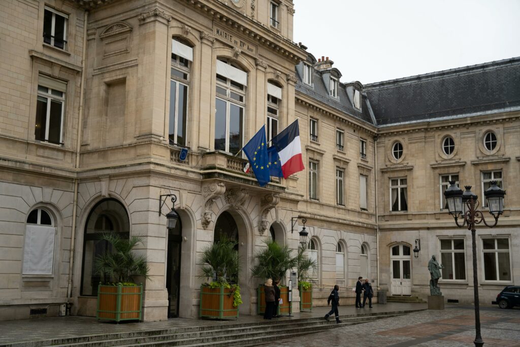 Bâtiment français avec drapeaux et statues dans la cour
