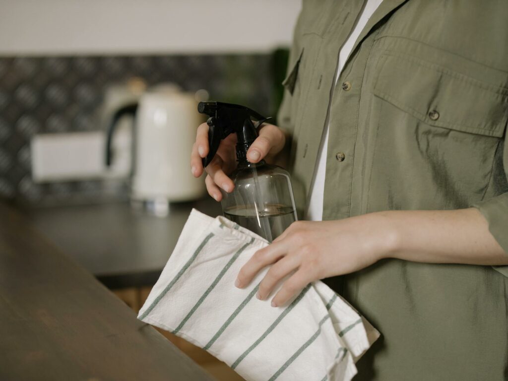 Personne en chemise verte tenant un verre à boire transparent