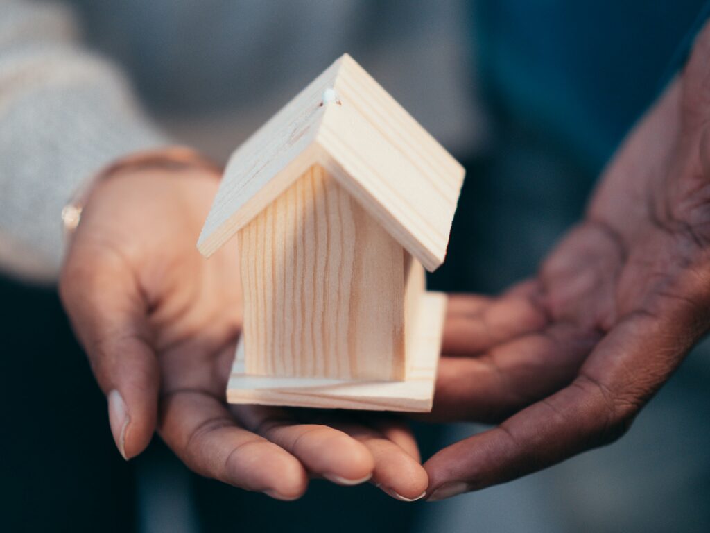 Personne tenant la maison en bois miniature