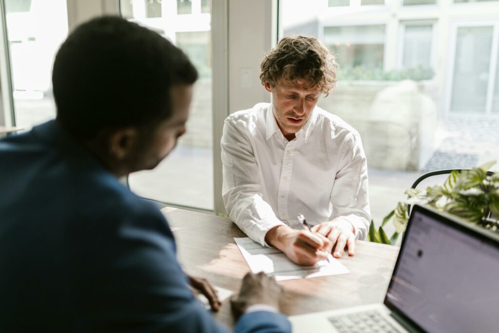 Un homme qui signe un document dans un bureau
