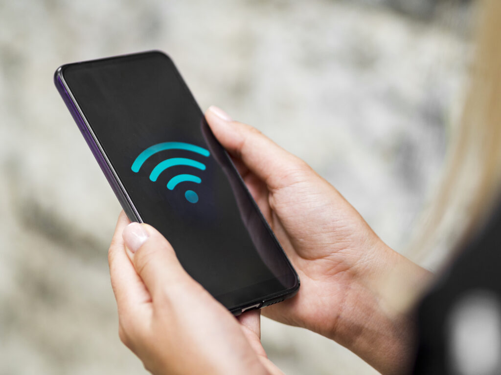 Téléphone en gros plan dans les mains avec symbole wifi