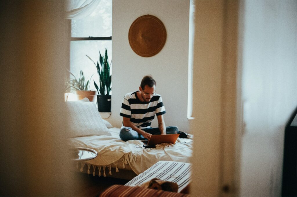 Man is sitting on the bedroom and working