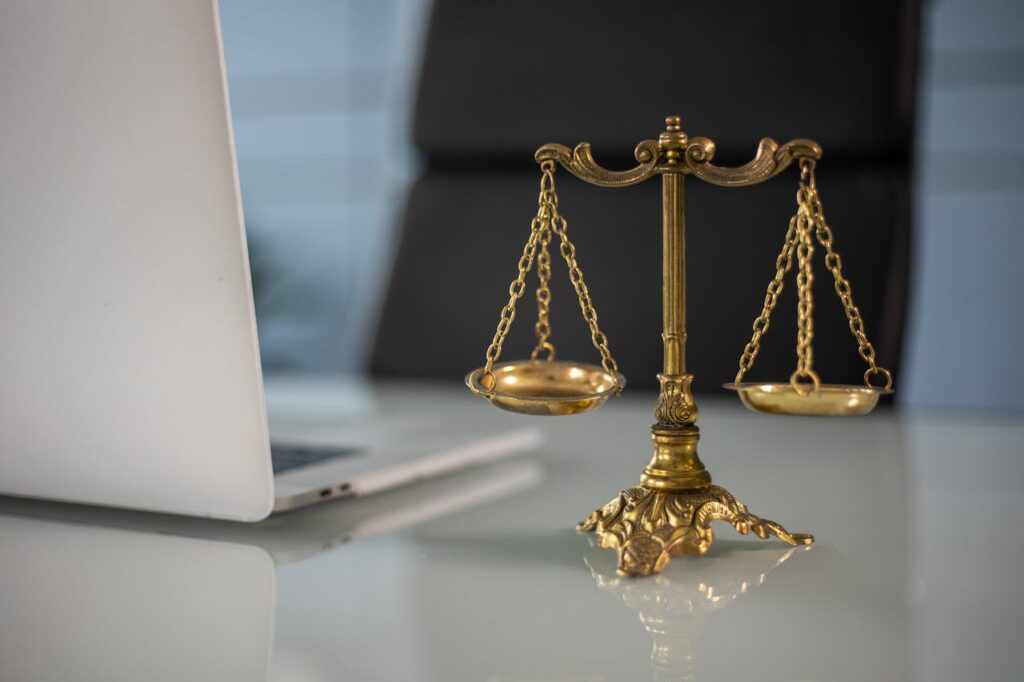 Golden Balance Scale beside a Laptop