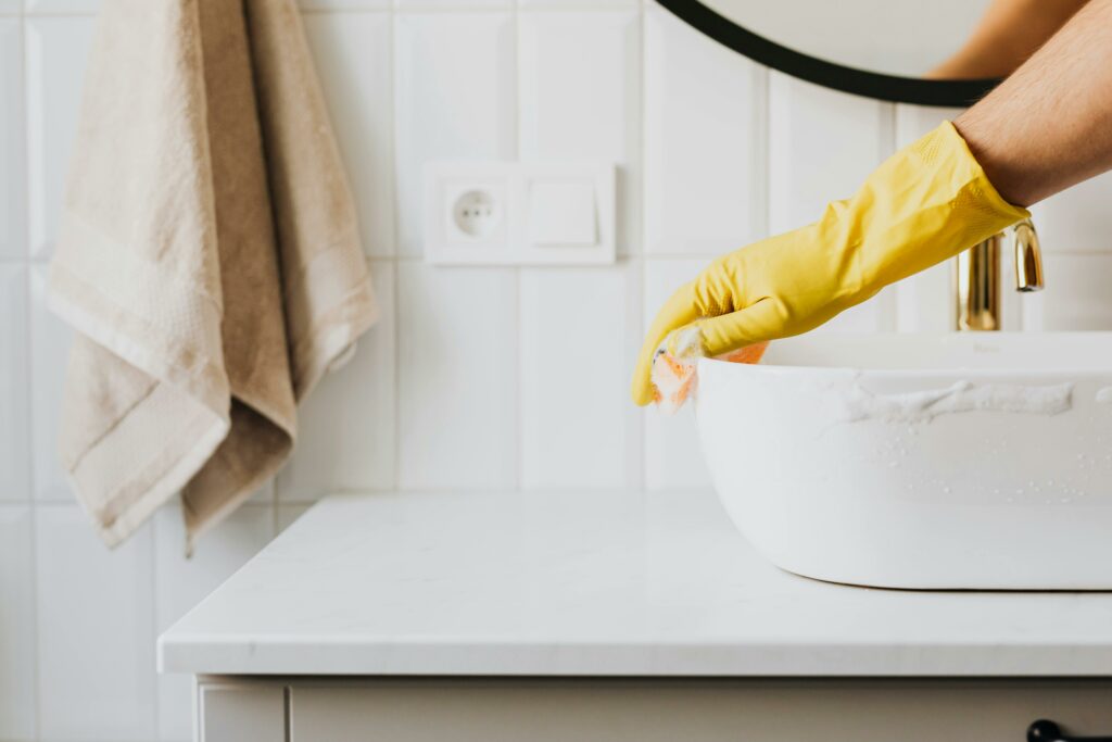 Personne méconnaissable lavant l’évier dans la salle de bain
