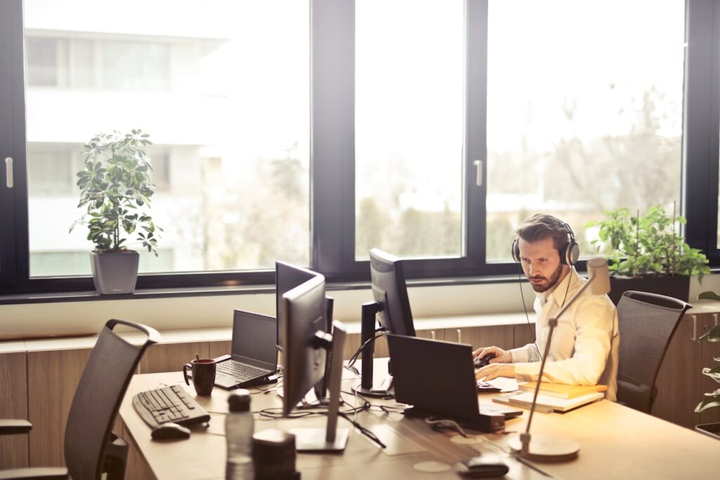 Homme avec casque face à un moniteur d’ordinateur