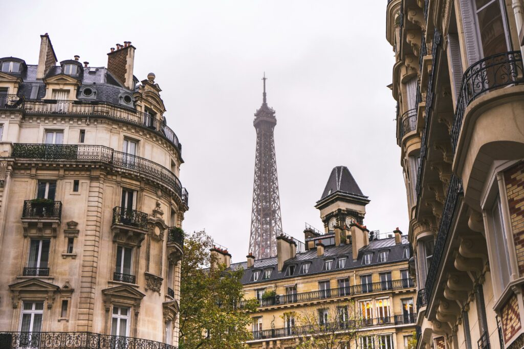 Haut de la tour Eiffelavec des bâtiments anciens au premier plan