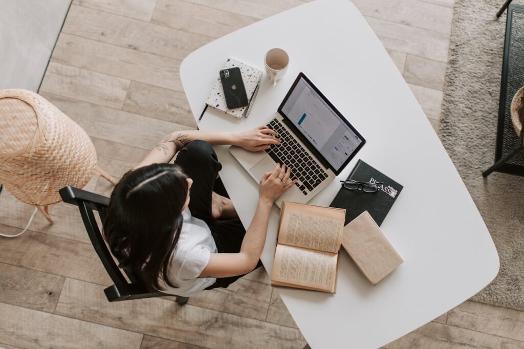 Jeune femme tapant sur le clavier de l’ordinateur portable dans le salon
