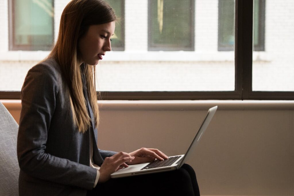 Femme assise et utilisant un ordinateur portable