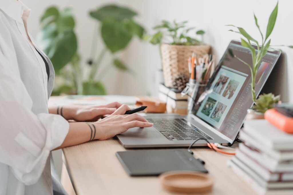 Femme travaillant photo de retouche sur ordinateur portable à un lieu de travail pratique