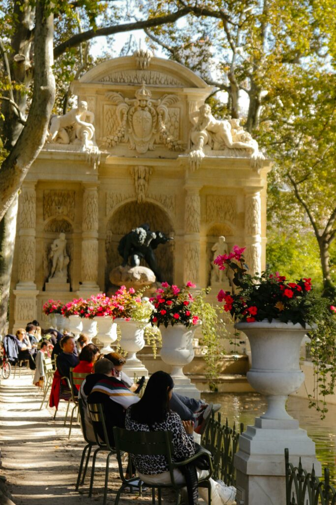 People Sitting on Chairs by the Fountain